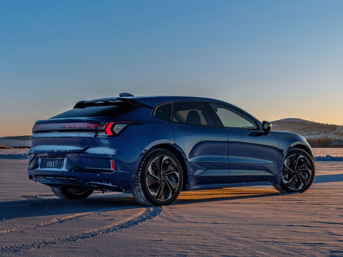 man watching a band on the stage wearing a red t-shirt and black hat.